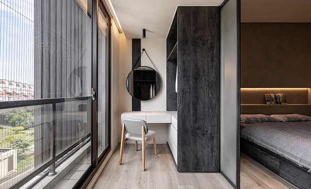 
主卧
Master Bedroom

主卧回归纯粹休憩机能，以屋主喜爱的轻工业风定调，使用斯曼特漆于床头背墙，创造清水模质感，并搭配黑色铁件元素，运用在床头吊灯、拉门、化妆镜等，形塑水泥冷调氛围。另因主卧邻近车道且坐拥大片落地窗，屋主希望能加强遮旋光性和隔音效果，因此格局配置上将更衣室与化妆间向外推，透过拉门和窗帘，降低日照影响和室外声响干扰，使获得舒适静谧的睡眠氛围。

In a concrete style, cement textured paint finished the bed head wall, imitating fair-faced concrete coating, coheres with black iron elements from the pendant lights, sliding door, and mirror to deliver the homeowner's favorite loft style and settle the restful zone. Considering the large French window and the location next to the driveway, we configured the walk-in closet and dressing room in front of the window to enhance soundproofing and shading. Therefore, the sliding door and curtains render a comfy and tranquil sleep zone, blocking daylight and exterior noise.
