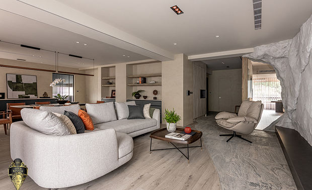 ▲壁面工艺是风格形塑的灵魂所在──设计团队及工班师傅以泥矿涂料手工逐层推敲琢磨，塑造兼具岩壁厚重感和漂流木有机纹理的艺术主牆，并揉入大小不一的云母片，随自然光的流移闪烁细微星光，使牆面超越装饰的定义，成为居所情感叙事的无声见证。
