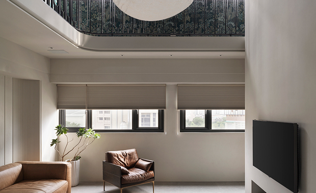 本文由OPEN编辑部撰写

如何活用楼中楼特色格局？藉楼层转换实现风格迥异的绝美双层空间！

低调深邃的水泥纹路于柜面漫展，所到之处驻留光影与时间，让人途经此处时不自觉放慢步伐，沉淀一切思绪。穿过客厅、拾阶而上，阳光在眼前恣意流洩，穿梭于活泼的壁纸花色与细腻栏杆造型间，勾勒一幅异于一楼调性的明媚欧风画卷，令身心顿时豁然开朗，尽情体验彻底放鬆的自在舒心。

澄境设计 设计总监 郑抿丹 为给予屋主夫妻及三名孩子隽永宜人的家园，遂以全室无毒绿建材扎稳安心生活的根基。随后考量各人的兴趣及习惯，活用楼梯位于电视牆后的立面空间，规划顶天的书牆与收纳区，提供男主人阅读或弹奏吉他的隐密天地；二楼定位为孩童游戏区，精心量测间距的订製弧形栏杆，造型优美之馀确保儿童嬉戏时的安全；一旁则善用阳台安置换水系统，实现女主人拥有海水鱼缸的梦想。双层开放设计令人们交流无虞，乐声与笑语交织，谱写一家人多采多姿的日常。
