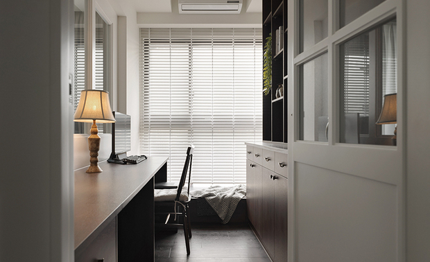 
书房──窗隙时光 小隅自得的安然时分

白色玻璃格扇门轻掩之后，书房自成一方内敛天地。深色长桌沿牆铺展，桌角檯灯散着琥珀暖光，窗前百叶将日光裁成细线，在桌面上描绘流动的光束节奏。靠窗卧榻随手搁上织毯便是午后小憩的归处，既安放思绪，也容得下片刻放空的閒适。
