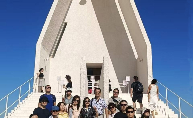 秦皇岛‧阿那亚地区:满盈独创艺术性的综合性文旅社区
在五天四夜的旅程中,更有一处考察区域足足停留两天,供商务考察团队深入鑽研──「秦皇岛‧阿那亚社区」。阿那亚社区之名称来自梵语「Aranya」,意谓「人间寂静处」,园区内部建有国际闻名的孤独图书馆、礼堂、美术中心等艺文建设,周围还具有沙滩、湿地和林地的多样天然景緻,使前往拜访的旅客们在享受入住酒店的高品质生活设施同时,亦可沉浸于自然及艺术的美好之中。
帝特设计的两位总监与一众设计师挖掘此项目的成功原因,是因社区将建筑设计、户外景观、艺术文化与观光活动,由内至外完美融汇一体,围构符合现代人热爱的「简约文青风」建物,配合文创展览之美、清幽海边美景,以及更多休閒放鬆的优质活动,一方面呈递「Aranya」品牌沉淀身心的核心理念,一方面令观光群体乐意打卡拍照、分享至社群软体,进而达到宣扬社区特色的目的。综合全方位的独创文旅地区,使考察团参与者无不大开眼界,并从中汲取商空公设设计的划设精髓,增加日后彰显商空品牌特质的可行方案。