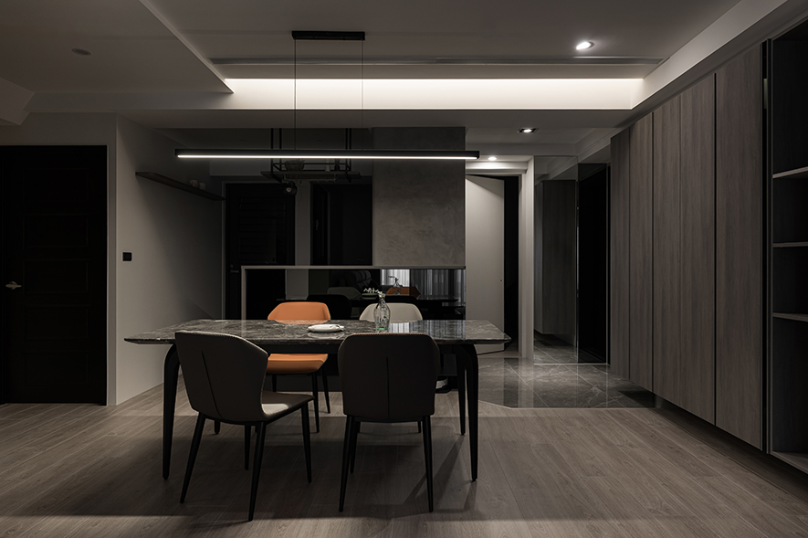 
餐厅——灰韵石语 铺展雅致食光

格局巧变，侷促尽褪，敞阔之境豁然铺展。匠心独具的亮面吧檯悠然伫立，虚实交辉间漫涌一室风雅气韵，无声衔接公领域的沉稳脉络，旁侧巧藏丰沛机能的电器与高昇柜体，维繫画面清朗从容；中央，深邃石纹餐桌似一方墨玉安卧，天然纹理宛若山水画卷在檯面上徐徐展开，灰色与橘色皮椅相伴左右，为飨宴时光平添几分儒雅风范，将日常餐叙昇华为品味生活的美好仪式。
