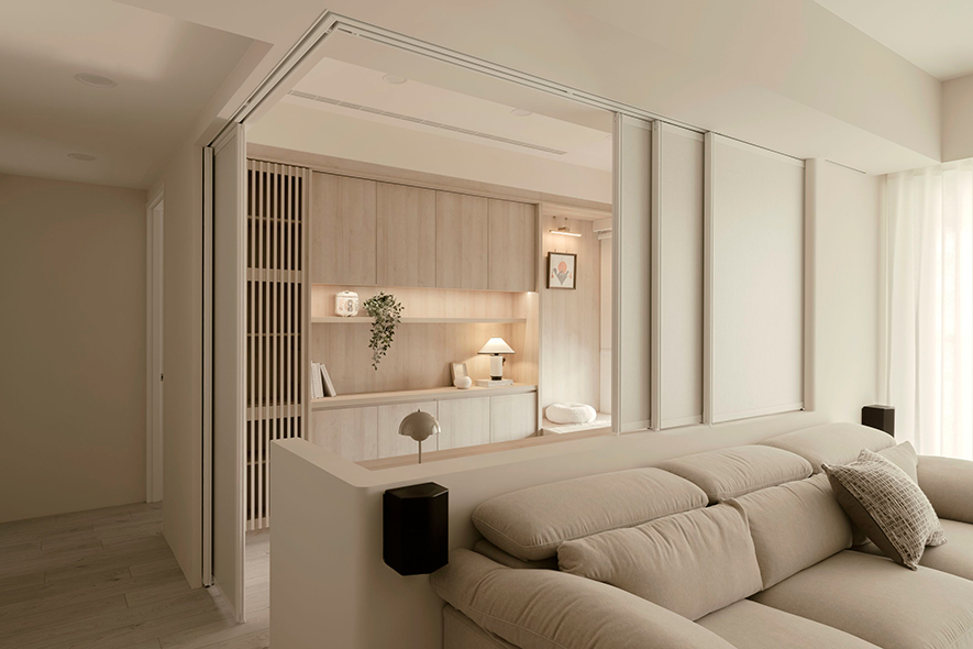 
多功能区——书香浅木 机能宁静场域

客厅沙发后方设半高牆面分划多功能区，并于近窗侧设置活动隔屏，可配合滑门将此区独立一室，赋予使用者阅读、憩息时所需的宁谧隐私环境；而内部设计整片轻浅木韵，和局部汇入的格栅造型、精心选置的古朴老藤椅及和风小物，酝酿出日系醇粹的典雅风范，加之临窗卧榻发散慵懒闲情，共筑一方假日休閒的最佳角落。

