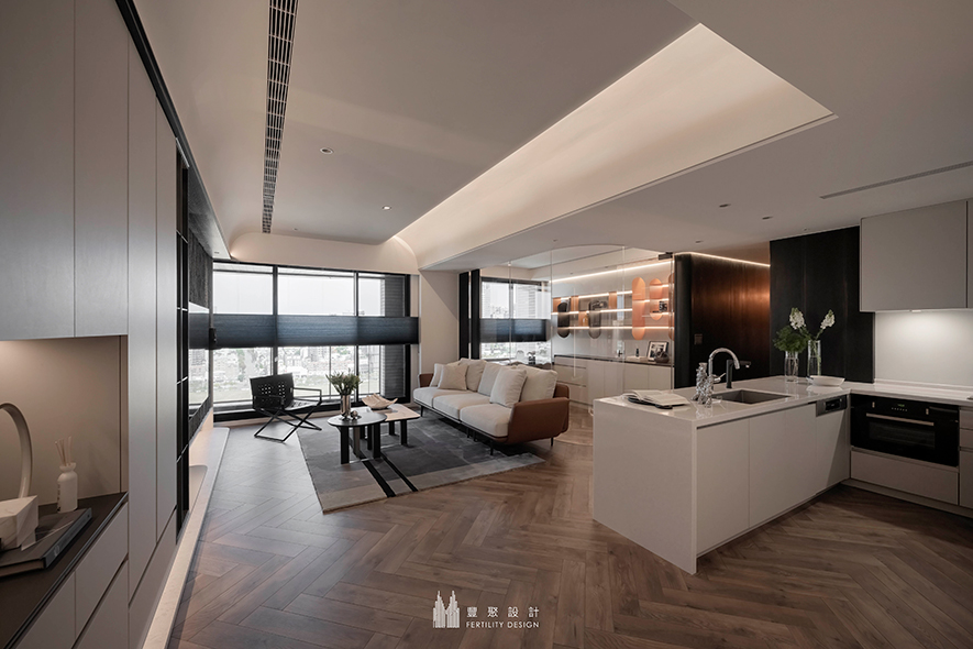 
本文由OPEN编辑部撰写

融汇天然异材及当代时尚的细緻柔景，陪伴居者共度精美奢雅的舒惬假期！

大面落地窗引入充裕天光，使流转的日夜光影及城市天际线，摇身成为妆点日常的天然画幅；在精緻异材铺叙的时髦环境间，居者轻倚吧台啜饮咖啡、或坐卧沙发遥望市景，日日皆彷彿化作度假的延伸，令身心在自然与奢雅之间，觅得恰到好处的舒心生活步调。

丰聚设计 设计总监 李羽芝、执行总监 黄翊峰 活用大片深邃沉静的木色，随场域深入逐步开阔为轻柔浅调，酝酿心境自沉淀转为放鬆的疗癒氛围。足下，人字拼木地坪飘逸文艺气息，与石条肌理壁面揉和出观感丰富的质感层次，辅搭曲弧天壁洒落的柔和间接光照，替屋宅增添和煦无压的温情暖意，亦在每寸片隅之间，真切诉说雍雅品味中独属屋主的生活物语。
