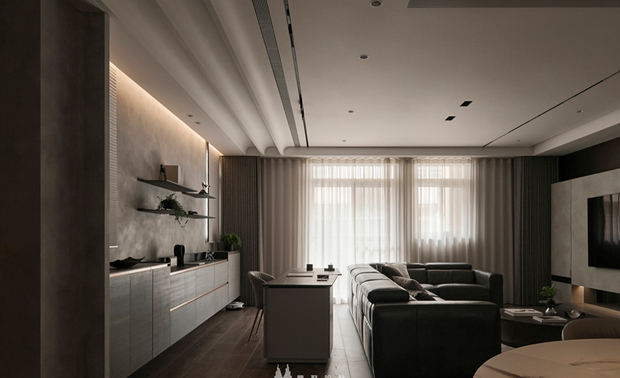 
客厅——沉稳雅致 材质对话的艺术场域

步入客厅，深色木地板传来踏实触感，每一步都彷彿走在沉稳大地上，让心绪逐渐安定。电视牆採浅色石材，在深色包围中如晨曦微光般宁静优雅，旁侧开放式展示层架嵌入牆面，温暖灯光照亮上方摆饰，每件物品都承载着生活记忆，静静诉说着属于家的故事。静坐在深色沙发上，身体渐渐被柔软包覆，一天的紧绷随之消散；而沙发后方的书桌区域，让阅读与休憩自然交融，随时都能转身沉浸于书页间的悠然时光。
