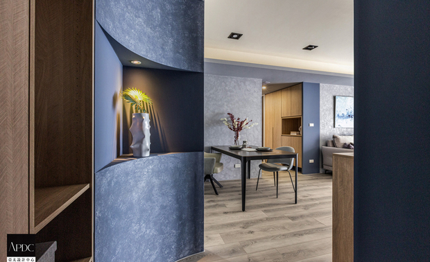 ▲玄关左侧设置结合置物平台的收纳柜，便于住者取放外出衣物及随身物品，一旁弧面艺术牆于中央设计一处展示区，令屋主珍藏之展品自然成为入门后视觉焦点，创造充盈个人风格的艺术端景。
