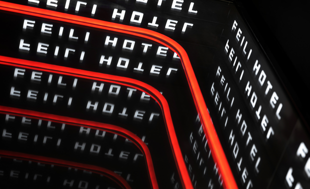 （酒店大堂等候区）

同时，将酒店的社交特性融入到设计中，以酒店公共区域为依托，通过精心规划的灯光、深渊镜和镜面金属等元素在丰富色彩变幻的同时为酒店增添时尚气息，还创造了一个放松的社交场所，满足了住客们的需求。同时，为线上社交平台的达人们提供了拍照和打卡的空间，这些设计策略有效地提高了酒店品牌的认知度。

02#
缤纷色彩+休闲时光

客房的走廊是所有住客的必经之路,是酒店空间中重要的组成部分。在翡丽酒店设计中，GDD深思设计将走廊以灯光为纽带，传递对时尚的追求。柔和的照明设计搭配原木色饰面板不仅能够满足功能性需求，还能营造出优雅、宁静的氛围，使住客在穿梭于客房之间时，感受到时尚的气息。同时，走廊的照明设计也能够突显空间层次感，增强视觉效果，让酒店的设计更具吸引力。

