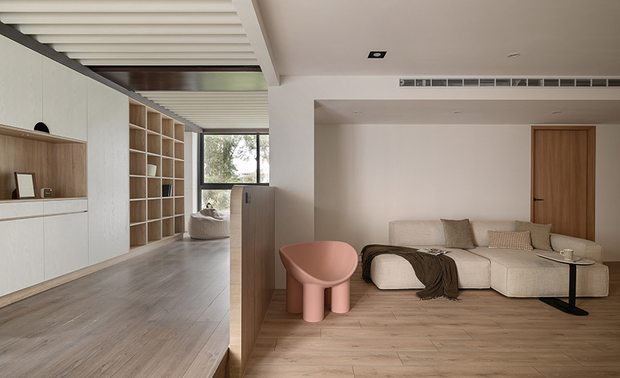 
起居室、书房——格栅光影 悠然书香

二楼的私密天地保留旧时的格栅天花与架高木地板，当阳光透过落地窗洒入，与其交织成错落有致的视觉层次；柔软的懒骨头沙发慵懒地倚在窗边，邀请主人在此沉浸于书海，后方的开放式收纳层架井然有序，既是知识的宝库，也是生活记忆的展示舞台。

转入相邻的起居室，閒暇时光裡，投影布幕徐徐展开，将这方天地瞬间转换为私人影院，让日常在灵活多变中绽放无限可能，新与旧的对话中，形成既是家人聚会的和乐角落，亦是独处时的心灵港湾。
