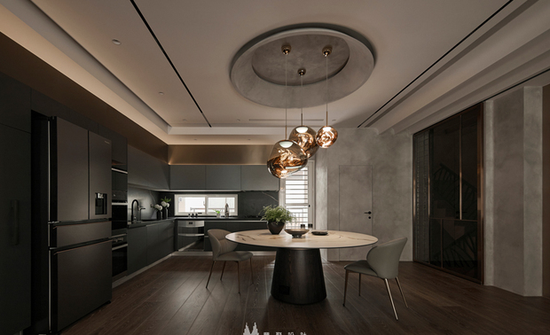 
餐厨区——圆满聚合 月盈星落下的温柔时光

一张圆桌，不只是用餐所在，更为情感汇聚的核心，承载着圆满与团聚的意象。抬头仰望，天花圆顶设计如月之盈，下方三颗玫瑰金球灯如星辰坠落般与之呼应成趣，在深色空间裡绽放静谧而奢华的光晕。无论是週末邀约三五好友小酌畅谈，或是深夜独自浅酌一杯红酒，这处餐厨空间都能给予最放鬆的陶醉氛围。
