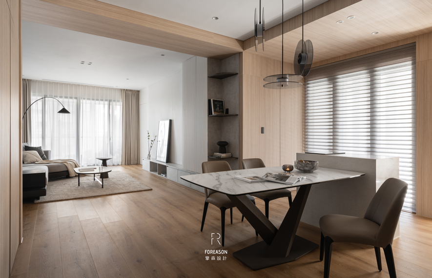 本文由OPEN编辑部撰写

当自然光成为最美的装饰 纯淨空间裡的生活美学

推开门扉，阳光如丝绸般柔软地洒落室内，在浅木色地板上晕染出柔和的光晕。视线沿着开阔的空间延伸，客厅、餐厅如同一幅流动的画作，在自然的动线裡层层叠出生活的景深；弧形立灯优雅地勾勒出一道弧线，彷彿捕捉时光的姿态。窗边的百叶帘筛落斑驳光影，让整个空间在明与暗、虚与实之间，呼吸着属于家的温度与从容。

擎森设计 设计总监 陈楚扉 以纯淨白色与温润木质作为空间基调，电视牆一侧整合开放层架与柜体，兼顾收纳与展示机能。餐厅区的大理石纹餐桌搭配造型俐落的黑色桌脚及灰棕色餐椅，展现低调精緻的生活品味。玻璃吊灯与窗外自然光相互辉映，为用餐时光增添仪式感。整体以「少即是多」的设计理念，透过材质、色彩与线条的细腻编排，打造既具当代美学又充满温度的理想住居。
