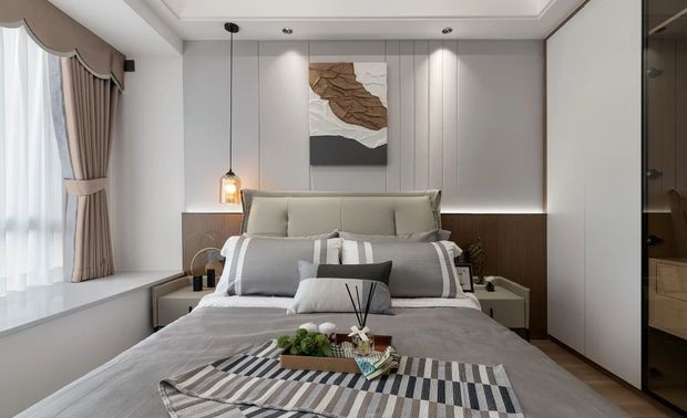 次卧的设计和主卧有所不同，色彩运用上使用饱和度低的浅灰色调。打造沉稳又不失柔和的“高级感”。一门到顶纯白衣柜，从视觉上拓宽了空间。背景墙以简约的线条提升了层次感，抽象挂画增添了空间艺术气息。GDD深思设计团队在次卧整体设计中充分考虑实际的需求，但又不失时尚感。