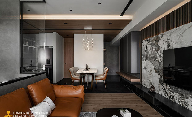 ▲公领域以白灰大板砖和灰泥涂料打造简洁时髦基调，搭配深木色格栅、地坪及橘褐软装，营造温润放鬆感，佐以间接照明平衡现代与自然的氛围，精美吊灯与壁灯增添视觉层次，塑造独特混搭风格。
