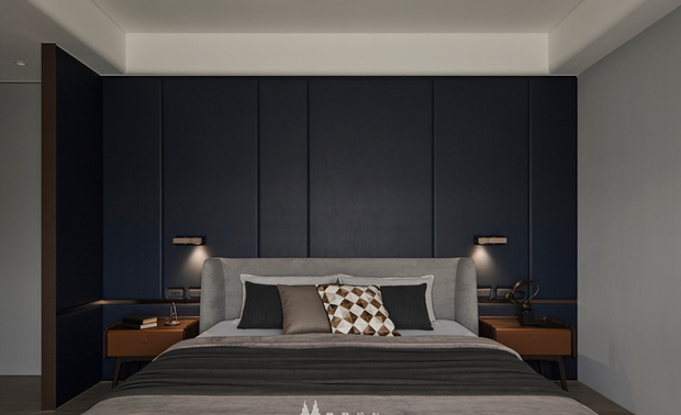 
主卧——静谧私语 沉稳中的温馨梦境

深灰色的整面床头背板如夜幕低垂，把日间的躁动轻轻隔绝。垂直线条则划分出简约大气的感受，让视线自在延展。两侧木质床头柜则带来自然温润的气息，搭配金色阅读壁灯，在深色背景衬托下散发如烛火般柔和光晕，为睡前阅读时光提供最温柔的陪伴。深色调带来的不是压抑，而是一种被轻柔包覆的安心感，彷彿被夜色拥入怀中。闭上双眼，此刻只需将身心交给这片沉静，在安然中缓缓坠入梦乡。
