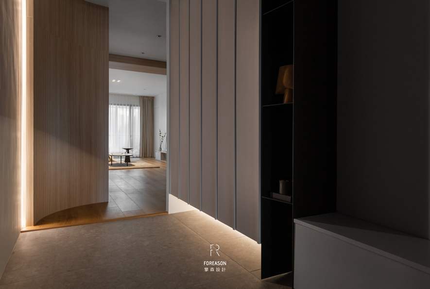 
玄关——光影引路的宁静迎候

踏入玄关的瞬间，柔润的间接光带如同温柔的指引，沿着木质立面与地面交界处悄然亮起，为归家的脚步铺陈一道和煦的光径。视线穿透弧形转角，远处客厅的明亮景致若隐若现，孩童的笑声与餐桌旁的谈话声隐约传来，那是专属于家的温暖呼唤。此处过渡空间不单是进出的动线，更是将外界匆忙与室内从容温和切换的仪式场域，让每一次推门而入，都化作心灵重新休整的起点。
