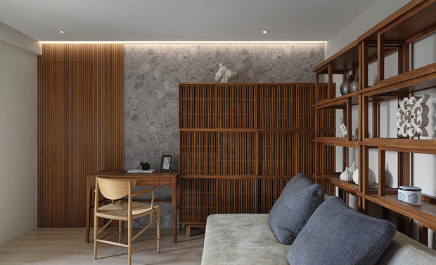 
主卧、书房——木石肌理流溢宁谧禅意 打造夫妻二人的专属天地

需兼具主卧及书房功能的此区，选配柚木家具及木质格栅奠下柔润调性，恰如禅景中的细水盆景润泽石面，化解灰阶石牆的冷硬感，佐搭间接灯光轻洒于层架与书桌的温润，在静寂中抹上原木澹澹的人文温度，予以夫妻二人屏去繁复装饰、围绕天然大地色系的沉心场域；当书香与木石相融，空间彷彿自内而外吐纳悠远平和之气息，营造舒缓身心的理想所在。

