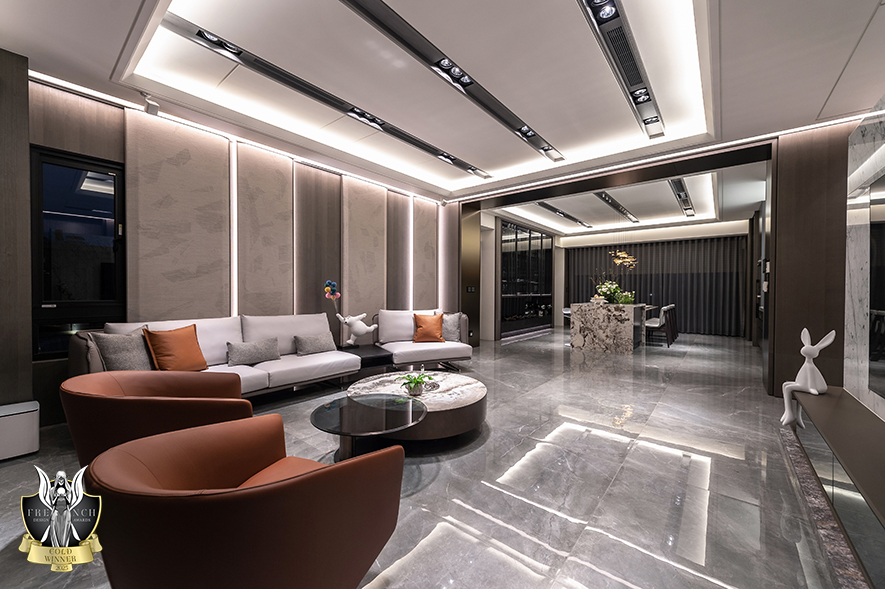 ▲由入门端景处延展至沙发背牆，编织牆毯的细腻斑纹铺设于微微倾斜的立面，搭配其间错落的褐色带状异材线条，为空间缀入丰富层次感。
