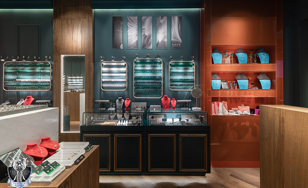 ▲展示区中段增设的L形橘色烤漆玻璃结构，藉由反射面提升亮度与画面层次，并作为狭长格局的视觉节点，转换空间节奏并带有舞台佈景感；两侧牆面的红色壁灯与吊灯，则以典雅造型与入口处的水晶灯遥相呼应，聚焦牆面上主力商品的同时，也营造充满热情活力的购物氛围。

华苇轩
纬纶设计 设计总监
电话：02-2701-8631
地址：台北市中山区中山北路三段26号11楼之3
信箱：weilun.ltd@gmail.com
网址：https://www.weilundesign.com/

OPEN Design 动能开启传媒：https://www.openworld.tv/