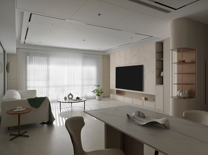 
本文由OPEN编辑部撰写

圆弧流线与纯淨暖调融合 构筑明亮无压的品味家居

推开家门的瞬间，一道流动的弧形廊道如同乐章的序曲，温柔地引领归家的脚步。心绪彷彿随着这灵动的流线轻快舞动，殷切期望转过弯后，那片纯淨柔和的米色暖意如拥抱般迎面而来，彻底洗淨一日在外的奔波与劳累，只留下「家」最本质的宁静舒缓。

本案为四口之家的温馨居所，澄境设计 设计总监 郑抿丹 以圆弧作为空间主轴，在入门处巧妙勾勒柜体的转折，让玄关与客厅之间的过渡更为流畅，形成和谐的韵律感。曲线不仅柔化长形格局的刚硬线条，更将电视牆与柜面边缘串联，让空间在素淨的浅色基调中，呈现出轻盈而诗意的生活氛围。此外，为实现屋主对安全无毒空间的期待，设计团队特别选用无甲醛建材与矿物涂料，从源头把关空气品质，创造舒适的绿色居住环境，以细腻的关怀守护全家人的生活品质与健康。
