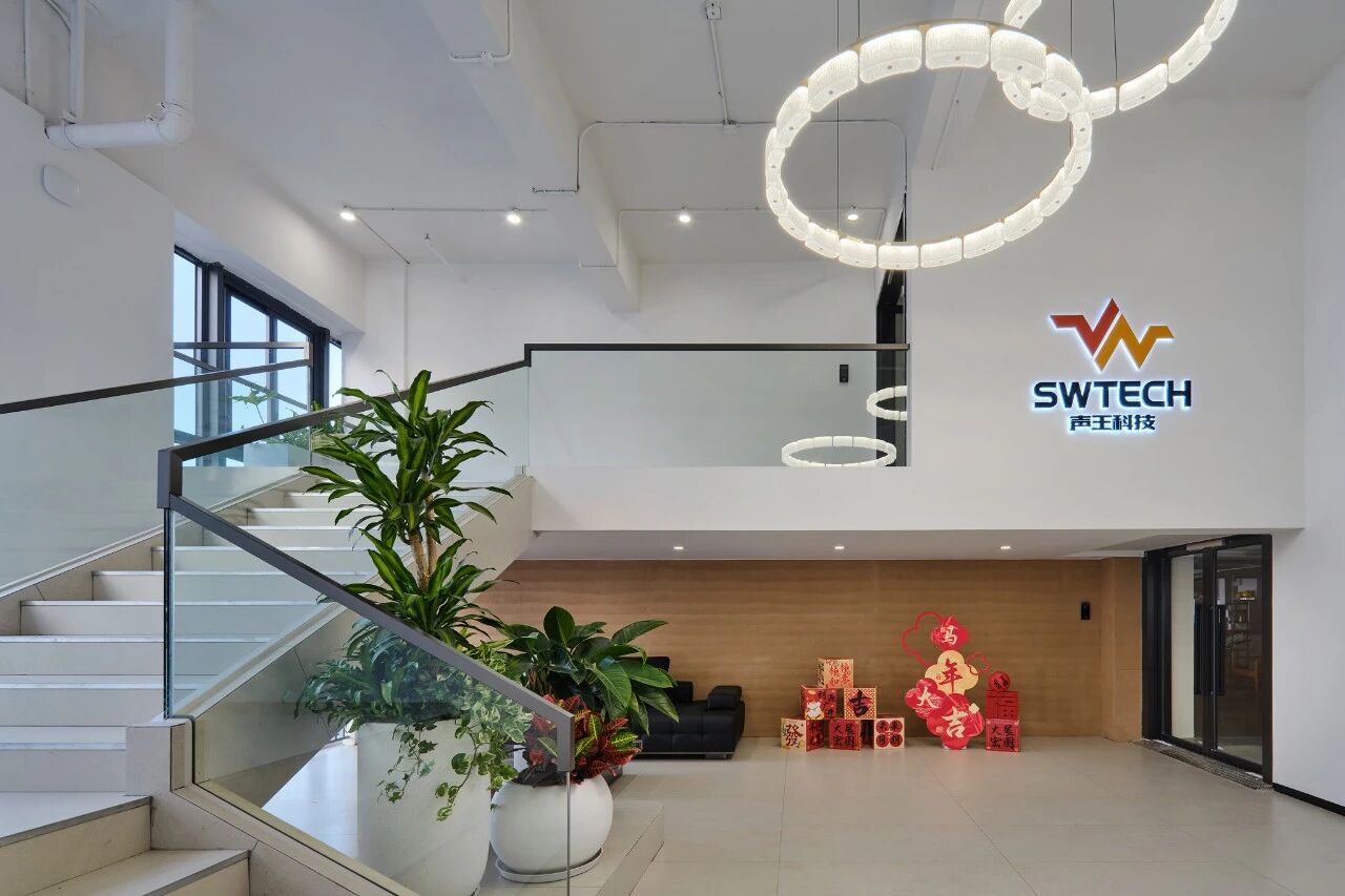 【大堂】

简约入境，方寸之间尽显格调

步入声王科技的一楼大堂，温润的夯土墙面与利落的现代线条形成鲜明对话。阳光透过大面积落地窗，在空间中游走，为硬朗的黑色皮革沙发与大理石茶几镀上一层柔和的光晕。