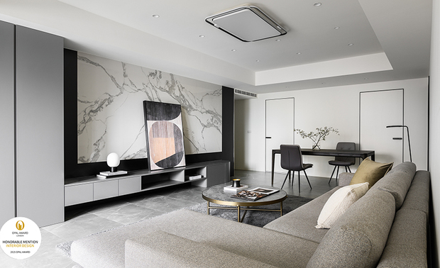 ▲客厅为维持空间纯淨与机能兼具，巧妙运用隐藏式收纳与门片整合，此外电视牆旁的深灰柜体收纳视听设备、儿童玩具与日常杂物，保持公领域清爽有序。
