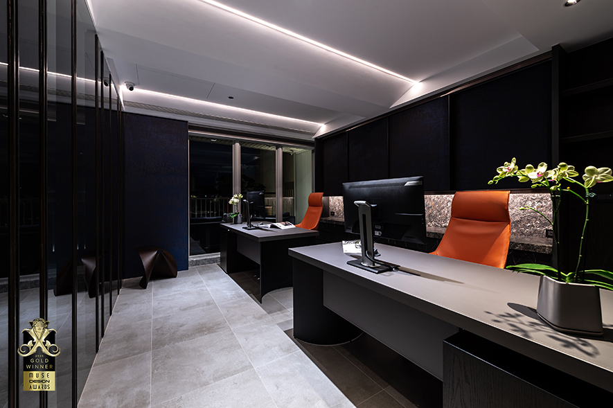 ▲主管室设置灰色玻璃隔屏保护隐私，并搭配暗色牆面与办公桌，亮橘色的座椅则为点睛之笔，于稳重氛围中注入一股活泼生动的气息。后方吊柜面贴编织地毯，与柜体的镀钛收边共组精緻质感，下方镂空区的立面与平台均为金色山脉花岗石，在灯光的照耀下闪烁金属光泽，优雅且大气十足。

郑敏娥、杨竣杰
沐筑设计 设计总监
电话：06-2508270
地址：台南市北区文成五路132号
信箱：muzhudesign@gmail.com
网址：https://muzhu-design.com/

OPEN Design 动能开启传媒：https://www.openworld.tv/