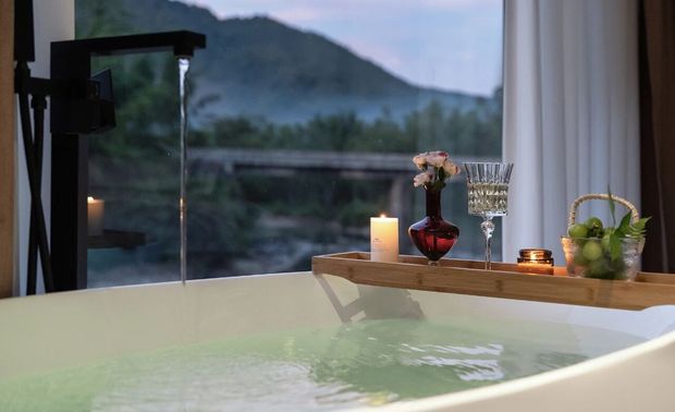 画面转入房内的飘窗与几近地面的落地窗，屋前的溪水萱草花田被纳为私藏的风景，是明艳艳的动人，在山林竹海中感受自然。