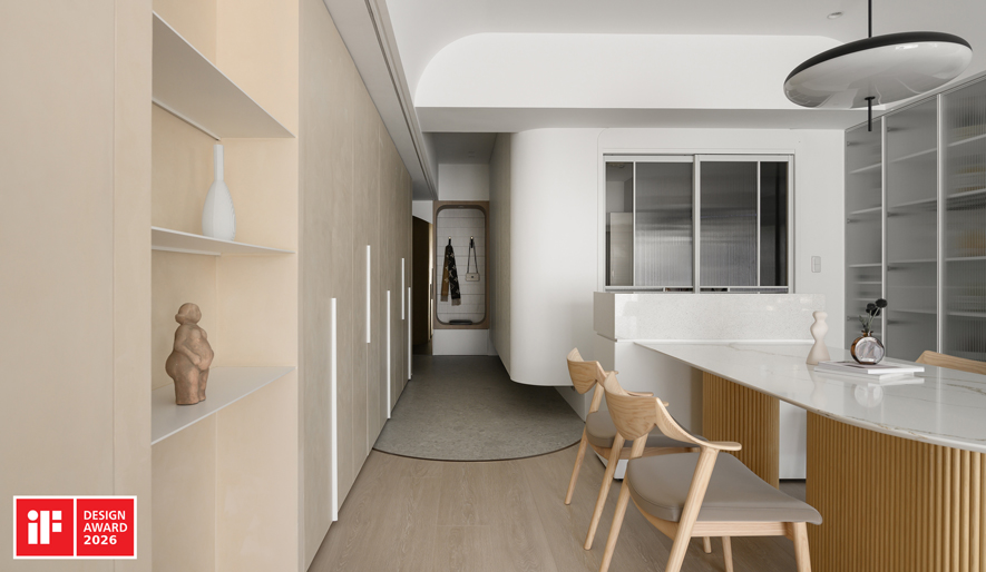 ▲玄关设木质圆框穿鞋椅兼具挂衣功能，搭配一旁圆弧茶镜营造简约的廊道端景；地坪採大面板水磨石砖呈现无缝质感，与室内木地板交界处以弧形镀钛铁件收边，呼应天花圆弧设计，为空间增添精緻亮点。
