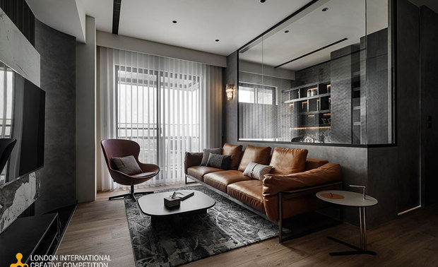 ▲客厅採黑白大板砖与木格栅双层电视牆，前后材质拼接展现冷冽与柔润的对比美学；圆弧窗畔设计则柔化立柱，增添空间流动感与趣味。
